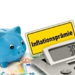 Sparschwein mit Taschenrechner und Schild Inflationsprämie